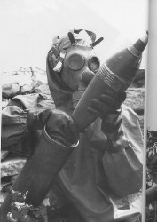Foto di un gerrigliero eritreo in maschera anti gas mentre carica un mortaio