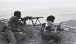 Foto di un guerrigliero mentre lancia una bomba in battaglia
