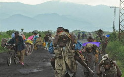 Immagine dei profughi carichi di oggetti e figli