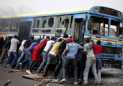 Foto:Congo ragazzi mentre allontanano una carcassa di autobus dalla strada